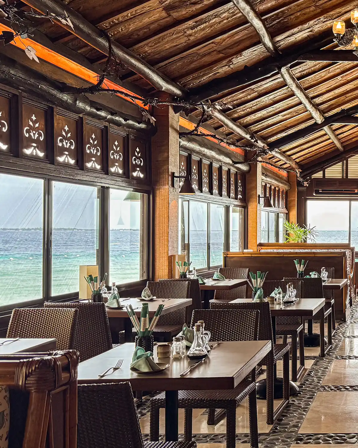 Fiji restaurant dining room under its timber roof, sea through the picture windows