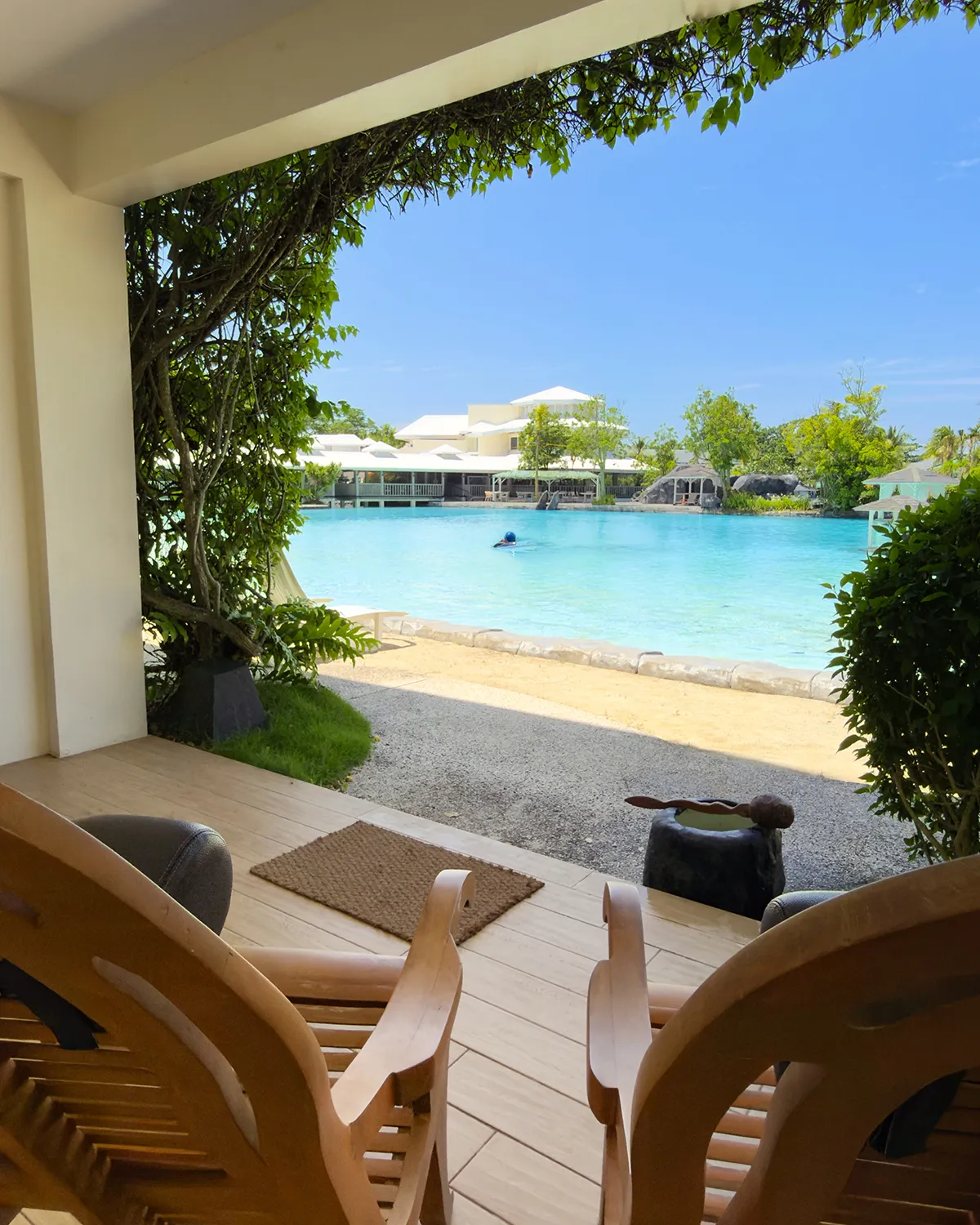 Sunlit balcony with butaka chairs looking out over the lagoon