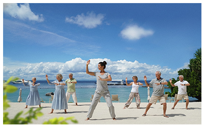 Group tai chi session on the beach at Plantation Bay